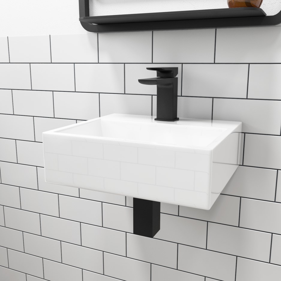 Modern wall mounted cloakroom basin with black tap.